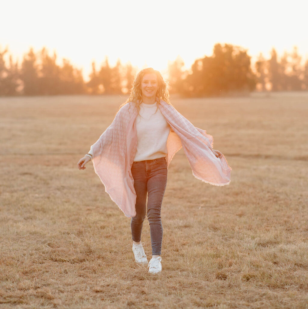 woman walking and smiling at sunset